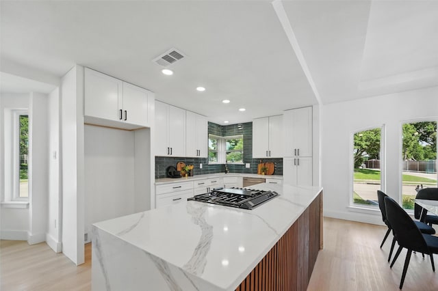 1429 Waterford Pl, Garland, TX 75044 - kitchen with light wood-style flooring, a center island, decorative backsplash, gas stovetop, and recessed lighting