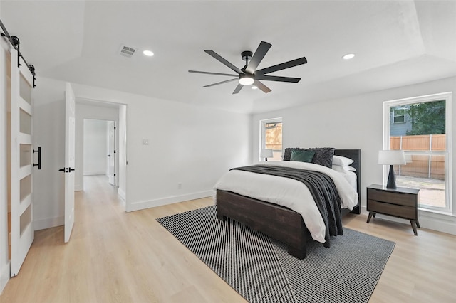 1429 Waterford Pl, Garland, TX 75044 - bedroom featuring a barn door, light wood-style floors, recessed lighting, ceiling fan, and baseboards