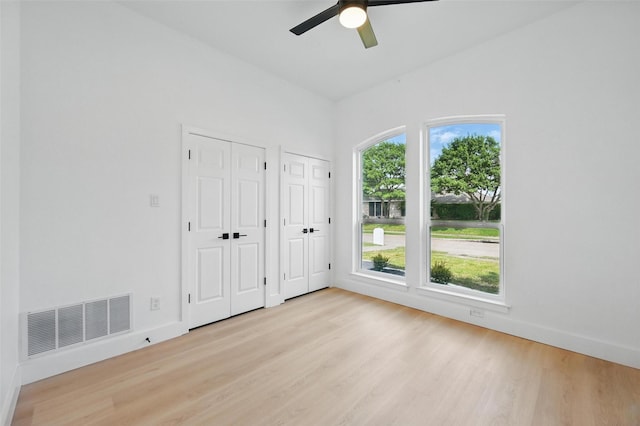 1429 Waterford Pl, Garland, TX 75044 - unfurnished bedroom with two closets, light wood-style floors, baseboards, and ceiling fan