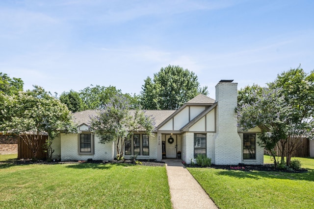 2928 Regal Rd, Plano, TX 75075 - tudor home featuring brick siding, a front yard, a chimney, and roof with shingles