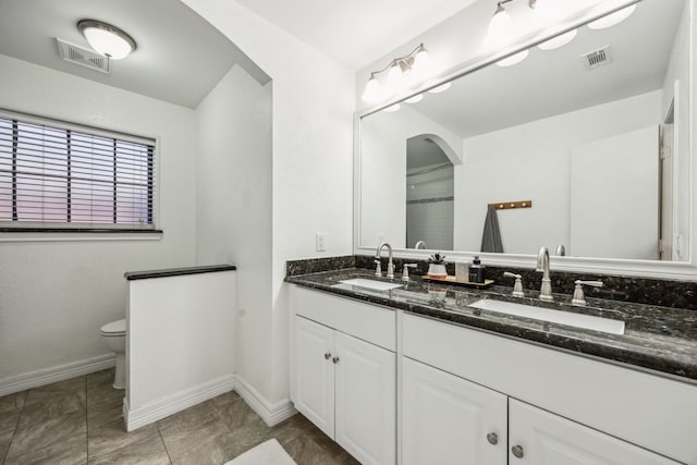 2928 Regal Rd, Plano, TX 75075 - bathroom featuring toilet, double vanity, and baseboards