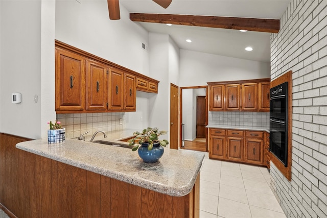 1210 Spring Lake Dr, Duncanville, TX 75137 - kitchen with a peninsula, brown cabinetry, backsplash, beam ceiling, and light tile patterned floors