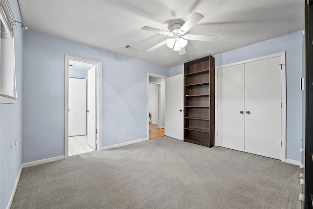 1210 Spring Lake Dr, Duncanville, TX 75137 - unfurnished bedroom featuring light carpet, baseboards, a closet, and ceiling fan