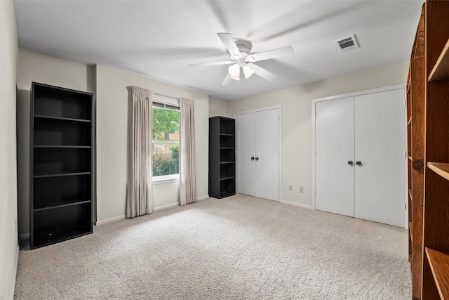1210 Spring Lake Dr, Duncanville, TX 75137 - unfurnished bedroom featuring two closets, carpet, baseboards, and a ceiling fan