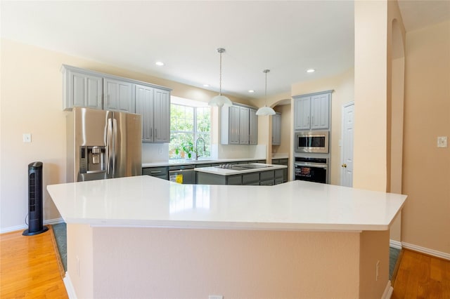2017 Rumson Dr, Arlington, TX 76006 - kitchen with stainless steel appliances, a spacious island, light wood-style flooring, gray cabinets, and recessed lighting