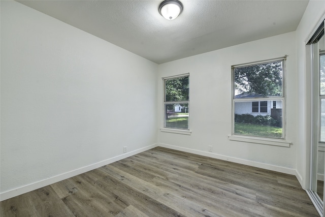 1601 Elizabeth Dr, Garland, TX 75042 - spare room with wood finished floors, baseboards, and a textured ceiling