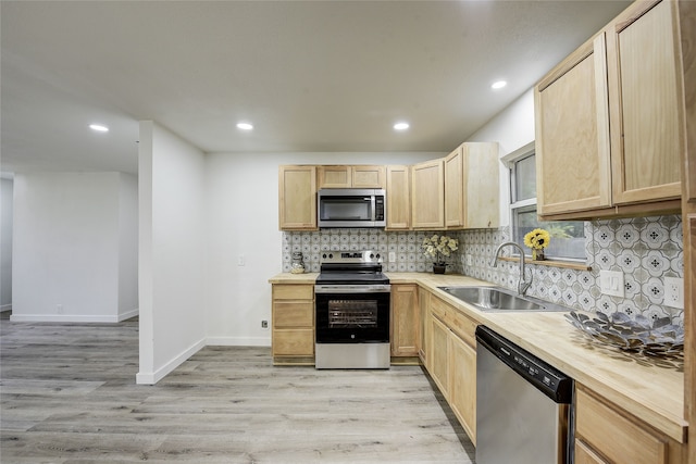 1601 Elizabeth Dr, Garland, TX 75042 - kitchen featuring appliances with stainless steel finishes, a sink, light brown cabinets, decorative backsplash, and light wood finished floors