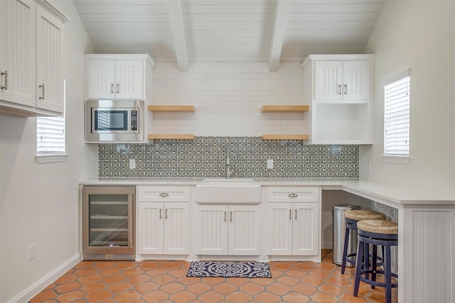160 Solano Cir, Aledo, TX 76008 - kitchen with open shelves, beverage cooler, stainless steel microwave, a sink, and white cabinetry