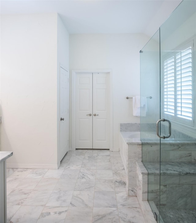 7002 Clear Springs Pkwy, Garland, TX 75044 - full bathroom with marble look tiles, a garden tub, a shower stall, baseboards, and a closet