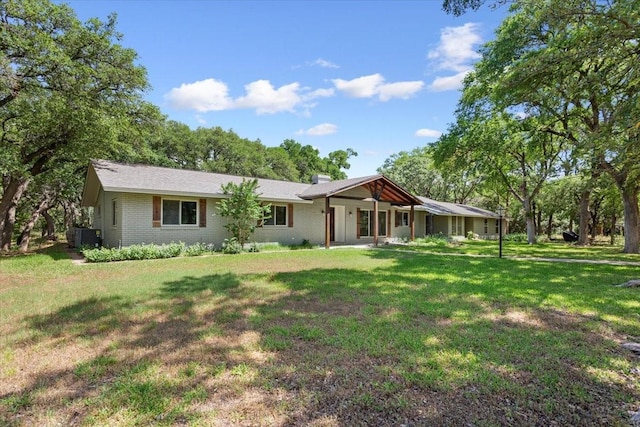 4732 Baylor Camp Rd, Crawford, TX 76638 - view of front of house featuring a front lawn, a chimney, brick siding, and central AC
