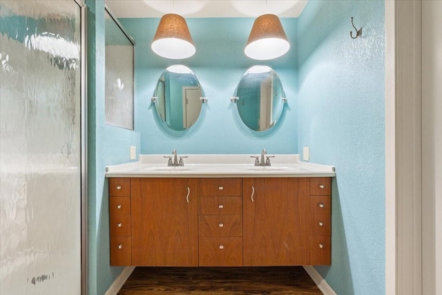 4732 Baylor Camp Rd, Crawford, TX 76638 - bathroom featuring double vanity, wood finished floors, a shower, a textured wall, and baseboards
