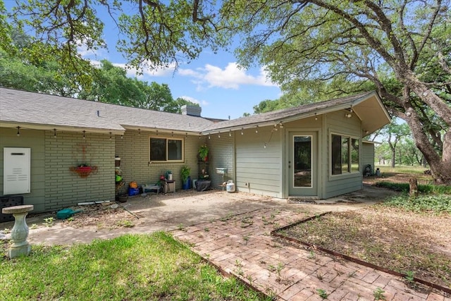 4732 Baylor Camp Rd, Crawford, TX 76638 - rear view of house featuring a patio, a chimney, and brick siding