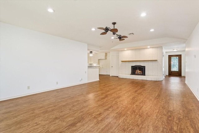 4732 Baylor Camp Rd, Crawford, TX 76638 - unfurnished living room with ceiling fan, lofted ceiling, recessed lighting, wood finished floors, and a brick fireplace
