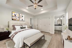 1320 E 3rd Ave, Corsicana, TX 75110 - bedroom with a raised ceiling, light wood-type flooring, recessed lighting, ensuite bathroom, and a ceiling fan