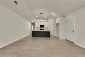 1320 E 3rd Ave, Corsicana, TX 75110 - unfurnished living room featuring light wood-style flooring, recessed lighting, and baseboards
