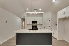 1320 E 3rd Ave, Corsicana, TX 75110 - kitchen featuring a sink, white cabinets, recessed lighting, a large island with sink, and baseboards