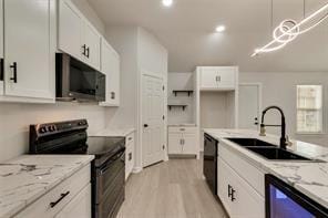 1320 E 3rd Ave, Corsicana, TX 75110 - kitchen featuring black appliances, a sink, white cabinetry, light stone counters, and recessed lighting