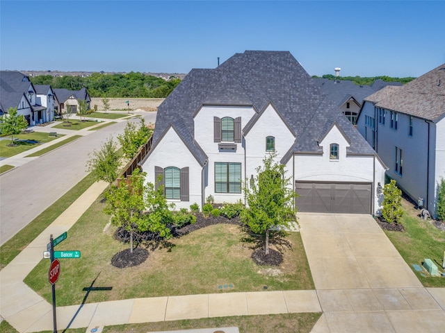 3525 Dancer Rd, Celina, TX 75009 - french country inspired facade with concrete driveway, a shingled roof, an attached garage, and brick siding
