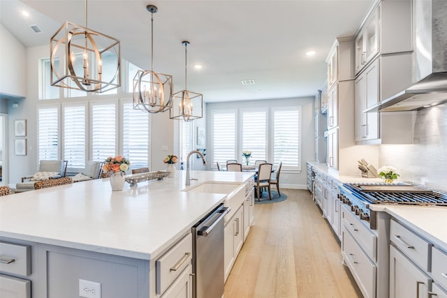 3525 Dancer Rd, Celina, TX 75009 - kitchen featuring wall chimney range hood, dishwasher, stovetop, a chandelier, and light wood-type flooring