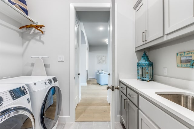 3525 Dancer Rd, Celina, TX 75009 - washroom with separate washer and dryer, cabinet space, and light wood-style floors