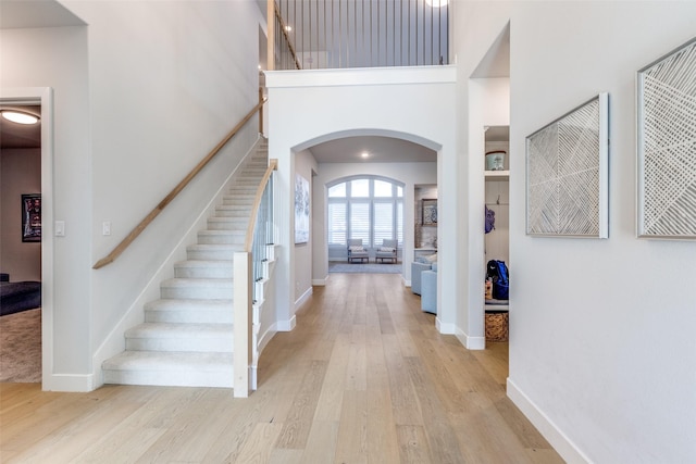 3525 Dancer Rd, Celina, TX 75009 - foyer entrance featuring arched walkways, stairs, light wood finished floors, and a towering ceiling