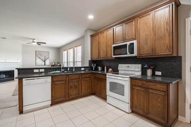 7807 Enchanted Isle Dr, Arlington, TX 76016 - kitchen with white appliances, a sink, a ceiling fan, a peninsula, and decorative backsplash
