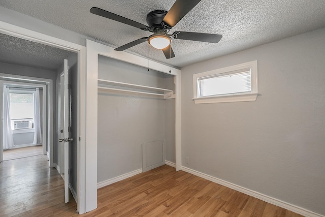 408 E Baylor St, Weatherford, TX 76086 - unfurnished bedroom with a closet, wood finished floors, a textured ceiling, cooling unit, and baseboards
