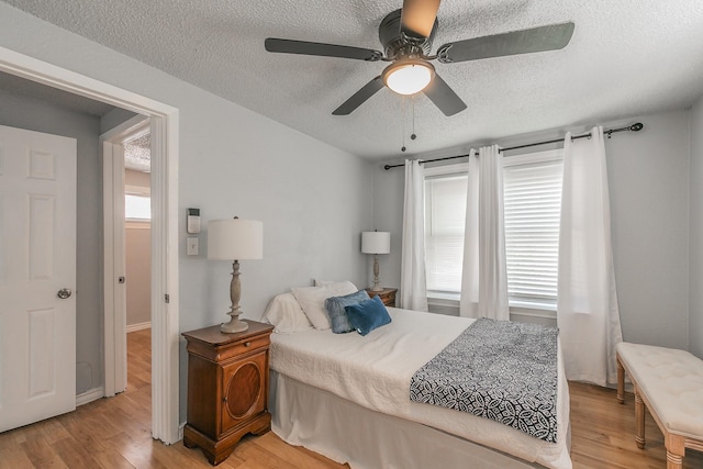 408 E Baylor St, Weatherford, TX 76086 - bedroom with a textured ceiling, light wood-style flooring, a ceiling fan, and baseboards