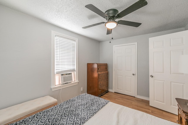 408 E Baylor St, Weatherford, TX 76086 - bedroom with cooling unit, wood finished floors, a textured ceiling, a ceiling fan, and baseboards