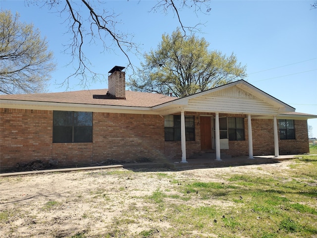 8740 County Road 2403, Tool, TX 75143 - rear view of property with brick siding, a chimney, and a lawn