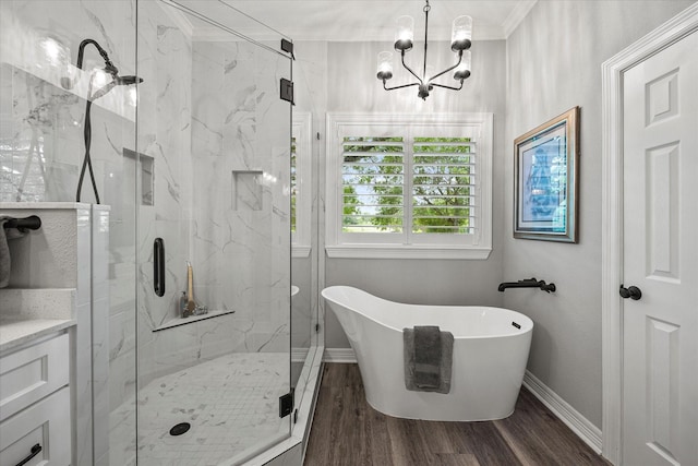 820 Windlake Cir, Heath, TX 75032 - bathroom featuring a freestanding tub, baseboards, a marble finish shower, ornamental molding, and wood finished floors