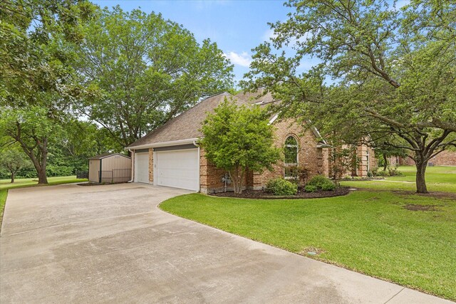 820 Windlake Cir, Heath, TX 75032 - view of front facade with concrete driveway, a garage, brick siding, a front yard, and a shingled roof