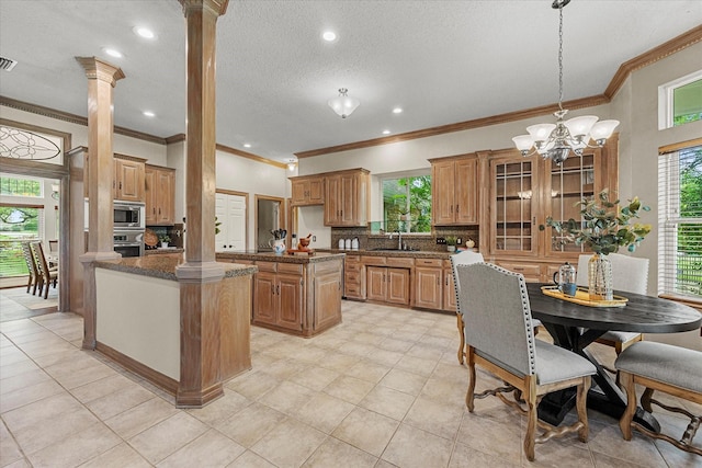 820 Windlake Cir, Heath, TX 75032 - kitchen featuring decorative columns, a sink, stainless steel appliances, a center island, and plenty of natural light