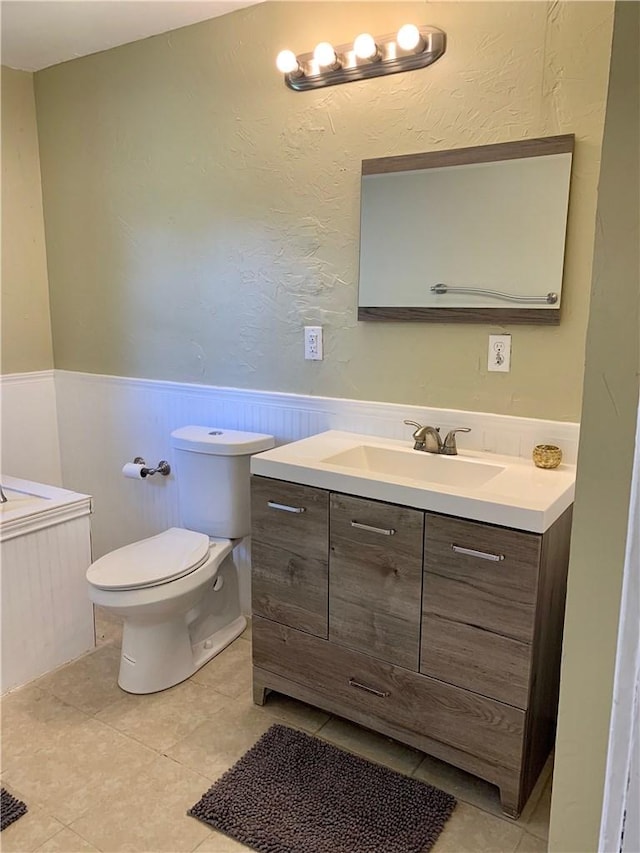 302 W Dexter St, Sherman, TX 75092 - bathroom with vanity, wainscoting, toilet, tile patterned flooring, and a bathtub
