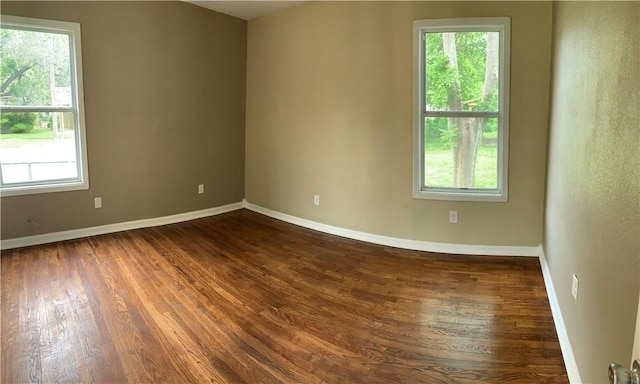 302 W Dexter St, Sherman, TX 75092 - empty room with dark wood-style floors, healthy amount of natural light, and baseboards