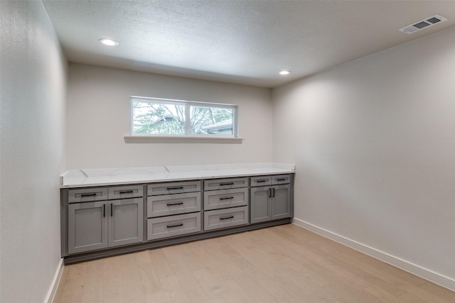 10240 Carry Back Cir, Dallas, TX 75229 - unfurnished room with light wood-style floors, baseboards, recessed lighting, and a textured ceiling