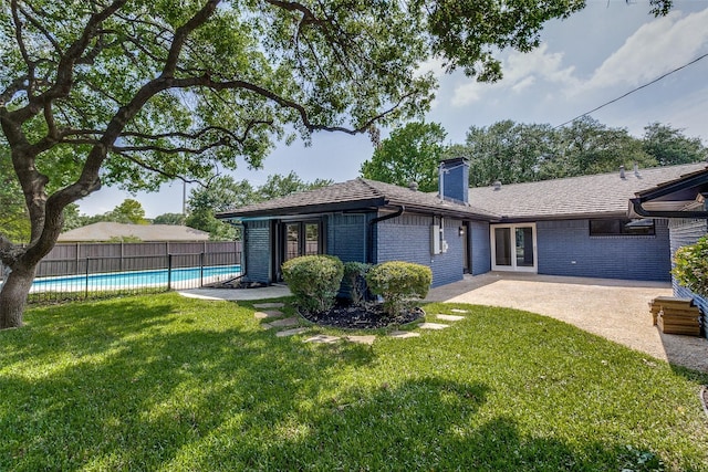 10240 Carry Back Cir, Dallas, TX 75229 - back of property featuring a chimney, brick siding, and a patio