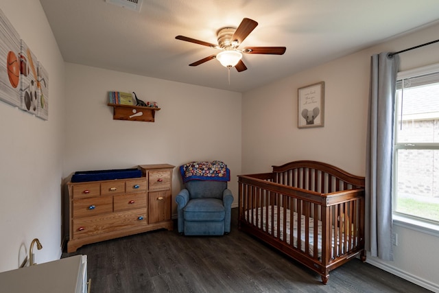 1003 Dewy Glen Ln, Princeton, TX 75407 - bedroom with dark wood-style flooring, multiple windows, a nursery area, and baseboards