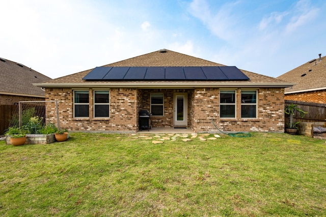 1003 Dewy Glen Ln, Princeton, TX 75407 - back of property featuring brick siding, a patio area, solar panels, and roof with shingles