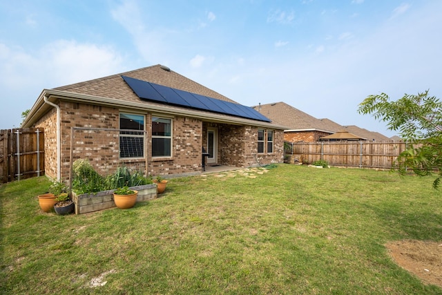 1003 Dewy Glen Ln, Princeton, TX 75407 - back of house with brick siding, roof mounted solar panels, and a shingled roof