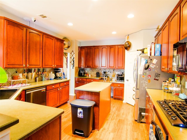 6 Altman Ct, Mansfield, TX 76063 - kitchen featuring appliances with stainless steel finishes, backsplash, light wood-style floors, a kitchen island, and light countertops