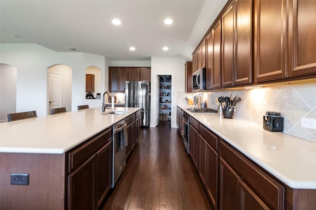 1424 Millican Ln, Aubrey, TX 76227 - kitchen featuring a sink, appliances with stainless steel finishes, arched walkways, dark wood-style floors, and recessed lighting