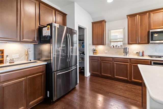 1424 Millican Ln, Aubrey, TX 76227 - kitchen featuring appliances with stainless steel finishes, backsplash, dark wood-style floors, lofted ceiling, and recessed lighting
