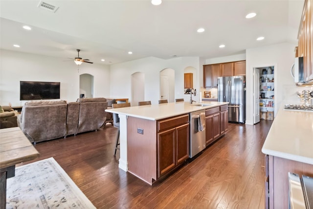 1424 Millican Ln, Aubrey, TX 76227 - kitchen featuring arched walkways, appliances with stainless steel finishes, light countertops, dark wood-style flooring, and recessed lighting