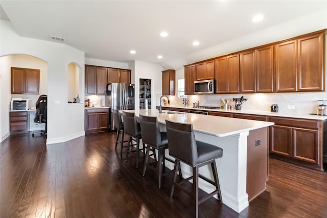1424 Millican Ln, Aubrey, TX 76227 - kitchen featuring stainless steel appliances, a breakfast bar area, a sink, dark wood-type flooring, and recessed lighting