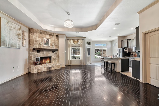 3113 Sangria Ln, Fort Worth, TX 76177 - living area featuring a chandelier, hardwood / wood-style floors, a stone fireplace, and a raised ceiling