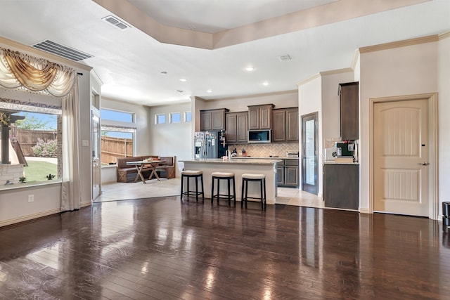 3113 Sangria Ln, Fort Worth, TX 76177 - kitchen with stainless steel fridge, light countertops, a kitchen bar, dark brown cabinets, and decorative backsplash