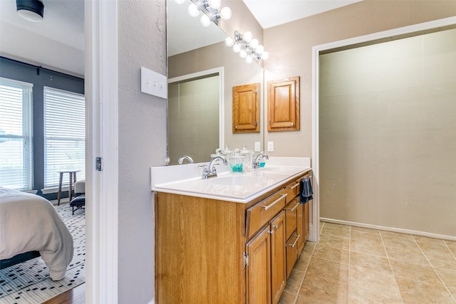 4223 Wild Plum Dr, Carrollton, TX 75010 - full bathroom featuring double vanity, connected bathroom, baseboards, a textured wall, and tile patterned flooring