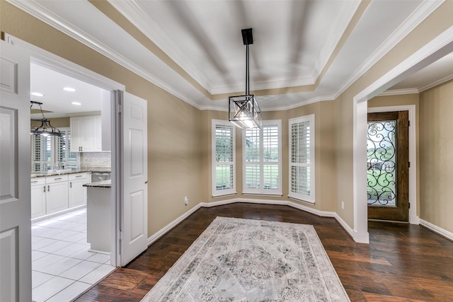 13914 Overlook Ln, Forney, TX 75126 - unfurnished dining area featuring healthy amount of natural light, a tray ceiling, dark wood-type flooring, a chandelier, and crown molding