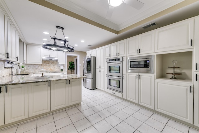 13914 Overlook Ln, Forney, TX 75126 - kitchen with appliances with stainless steel finishes, under cabinet range hood, a sink, crown molding, and light stone countertops